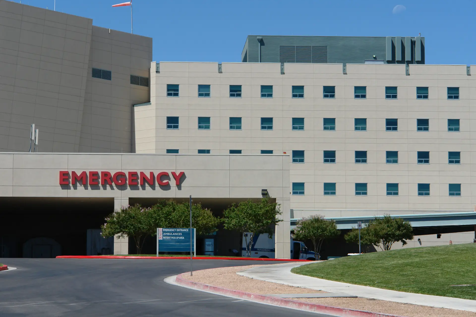 Modern emergency department entrance with bold signage and landscaped surroundings in a hospital setting.